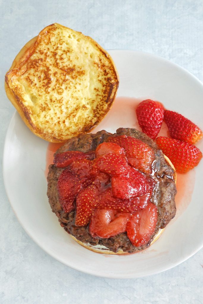 The strawberry french toast burger has a french toasted bun, cream cheese and is topped with strawberries.