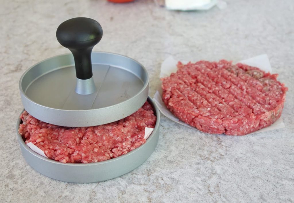 burger meat in a press
